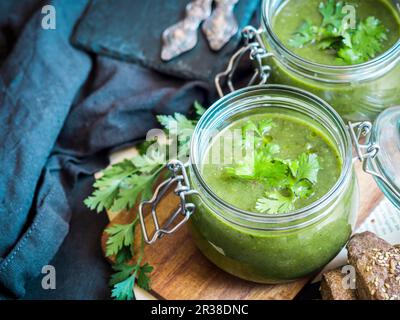 Vegane Creme aus gebackenen Zucchini, Süßkartoffeln und Spinatsuppe, serviert in Einmachgläsern Stockfoto