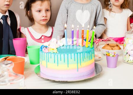 Das kleine Mädchen will diesen leckeren Kuchen probieren Stockfoto