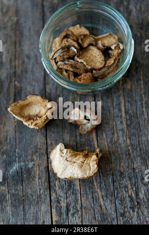 Getrocknete Steinpilze in einem Glas auf einer Holzfläche Stockfoto