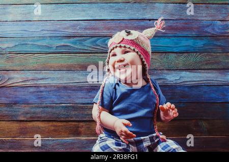 Smiling Baby in süßen Gestricken Eule hat Stockfoto