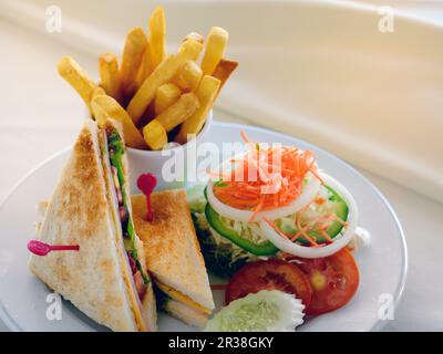 Ein Club-Sandwich mit Beilagensalat und pommes frites Stockfoto