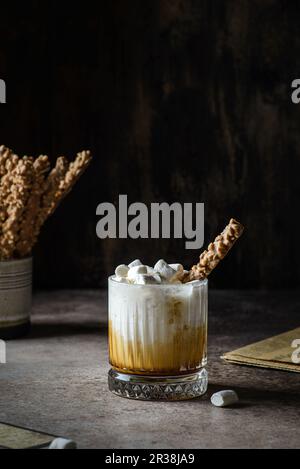 Milch mit Karamell auf dunklem Hintergrund Stockfoto