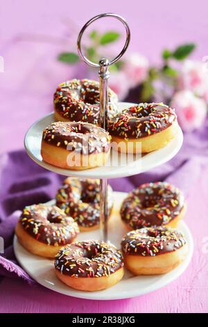 Mini-Donuts mit Sahnesauce und Zuckersträngen auf einem Kuchenstand Stockfoto