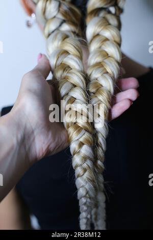 Zwei dicke Geflechte aus künstlichem Haar, junge Frisur, farbige Ha Stockfoto