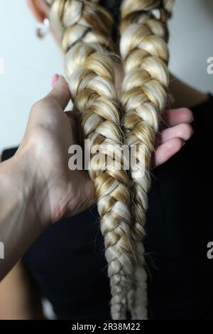 Zwei dicke Geflechte aus künstlichem Haar, junge Frisur, farbige Ha Stockfoto