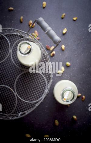 Hausgemachte Pistazienmilch mit Pailletten in Flaschen (Draufsicht) Stockfoto