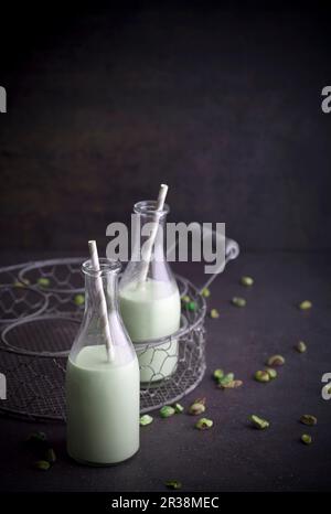 Hausgemachte Pistazienmilch mit Pailletten in Flaschen Stockfoto