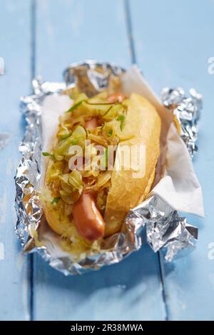 Hot Dog mit Gurke und Zwiebeln in Aluminiumfolie Stockfoto