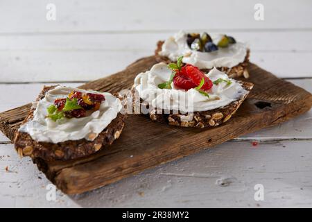 Vollkornbrot garniert mit Frischkäse und Obst (vegan) Stockfoto