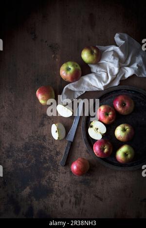 Äpfel auf einem Teller mit dunklem Holzhintergrund (Draufsicht) Stockfoto