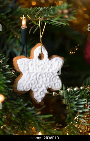 Lebkuchen-Schneeflockenkeks, der an einem weihnachtsbaum hängt Stockfoto