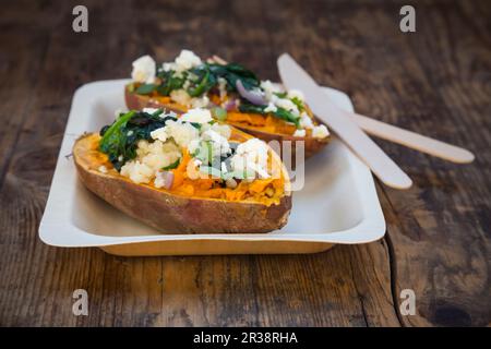 Gefüllte Süßkartoffeln mit Spinat, roten Zwiebeln, Couscous, Fetakäse und Koriander Stockfoto