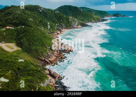 Malerische Küste mit stürmischem Ozean und malerischem bewölktem Himmel. Blick aus der Vogelperspektive auf die Berge und das Meer mit den Wellen Stockfoto