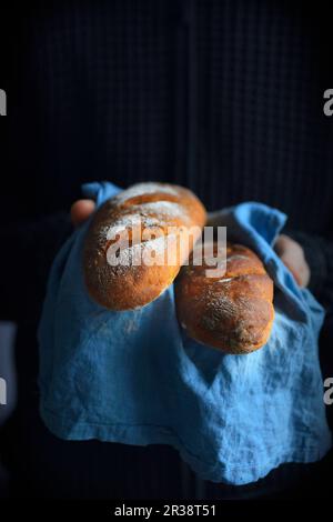 Ein Mann hält ein Baguette in der Hand Stockfoto