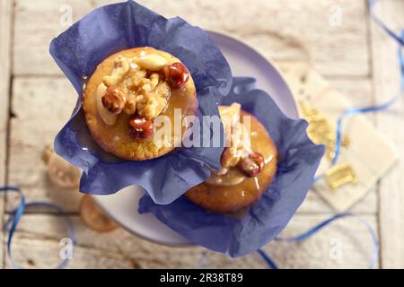 Toffee-Muffins in Papierkartons und auf einem Kuchenstand Stockfoto