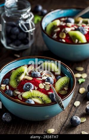 Erdbeeren-Heidelbeeren-Smoothie mit frischen Heidelbeeren, Kiwi, Kürbis und Sonnenblumenkernen Stockfoto