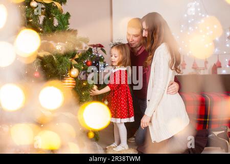 Glückliche Familie mit Tochter Weihnachtsbaum dekorieren Stockfoto