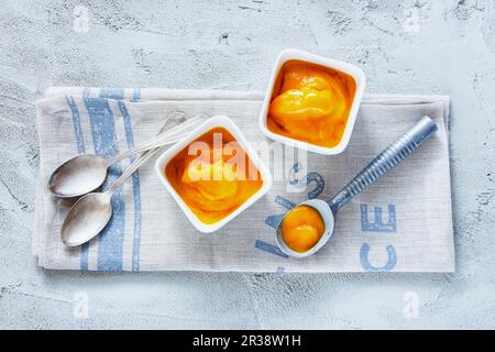Mango-Sorbet in einer Schüssel mit einer Eisportionierer Stockfoto