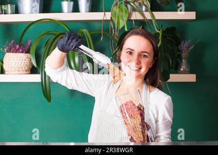 Junge Frau verkauft getrocknetes rohes veganes Brot Stockfoto