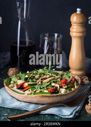 Roher Salat mit Erdbeeren, Zucchini, Rucola, Walnüssen und Käse mit Balsamglasur Stockfoto