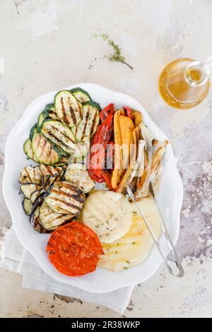 Gericht mit gegrilltem Gemüse, Zucchini, Auberginen, Paprika, Tomaten, Frühlingszwiebeln und Scamorza Stockfoto