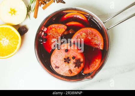 Glühwein in Aluminiumauflauf auf Marmorhintergrund Stockfoto