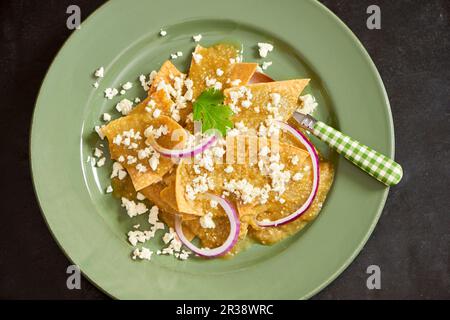 Chilaquiles (gebratene Tortilla) mit Käse und roten Zwiebelringen (Mexiko) Stockfoto