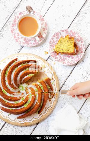 Einen Zucchini-Limetten-Kuchen aufschneiden Stockfoto