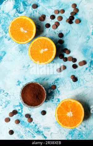 Orangen-Hälften mit Schokoladenstückchen und Kakaopulver Stockfoto