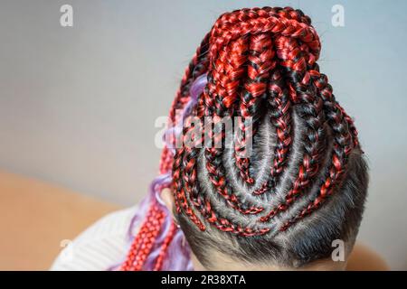 Cornrows Frauen häkeln wunderschöne Kanekalon-Locken, die mit einem Haken in das Haar gewebt sind, afrikanische Frisur mit künstlichem Haar Stockfoto