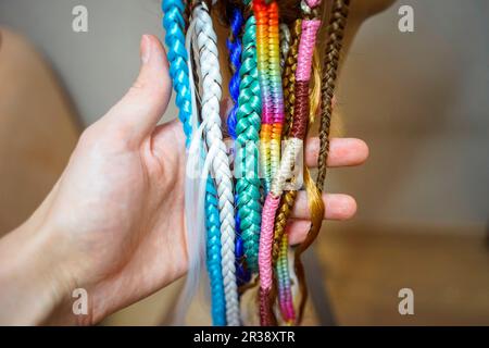 Rasta spanisches Mädchen mit Dreadlocks, Piercings und stilvolle Accessoires auf der blauen Wand. Stockfoto