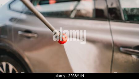 Autowaschanlage. Mann wäscht Auto auf dem Selbstwaschservice. Hochdruck-Wasser. Hochdruckreiniger. Das Auto reinigen. Stockfoto