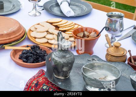 Mittelalterlicher Esstisch mit Keksen, Früchten und Gurken Stockfoto