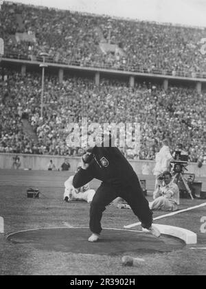 Olympische Spiele 1936 In Berlin. Die Olympischen Sommerspiele 1936 (deutsch: Olympische Sommerspiele 1936), offiziell bekannt als die Spiele der XI. Olympiade (deutsch: Spiele der XI Olympiade) und allgemein als Berlin 1936 bekannt, war eine internationale Multisport-Veranstaltung, die vom 1. Bis 16. August 1936 in Berlin stattfand. Der deutsche Schütze brachte den Champion Hans Woellke ins Olympiastadion. Er hat das Ereignis gewonnen. Stockfoto