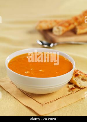 Karottensuppe mit Grissini Stockfoto