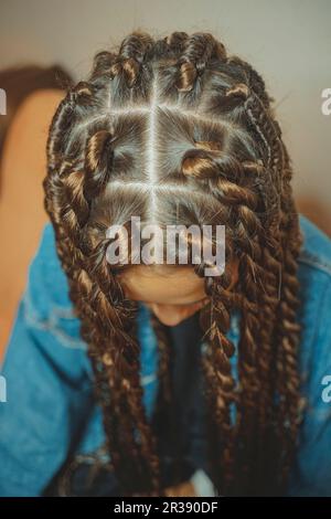 Dünne Zöpfe auf dem Kopf in afrikanischen Zöpfen, Dreadlocks, senegalesische Zöpfe, Twists, Mambo Twists Stockfoto