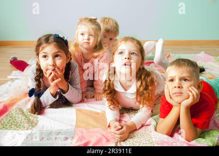 Nahaufnahme von fünf Kindern, die auf einer Etage lagen Stockfoto