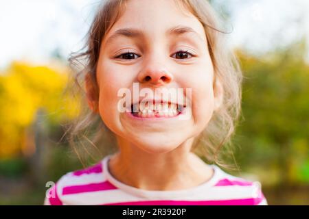 Lächelndes Mädchen mit dem ersten bleibenden Zahn Stockfoto