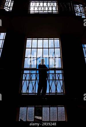 Silhouette eines Mannes, der auf der Treppe steht, in einem alten italienischen Gebäude, Zentralregion, Asmara, Eritrea Stockfoto