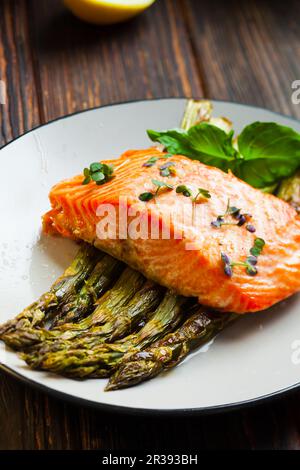 Gegrilltes Lachsfilet auf dem Spargel auf dem Teller Stockfoto