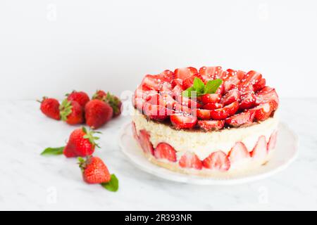 Erdbeerkuchen Fraisier auf dem weißen Teller und den Tassen Stockfoto