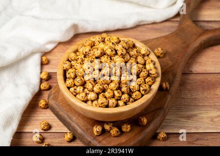 Gebratene Kichererbse. Geröstete Kichererbsen in einer Holzschüssel. Das Konzept der superfood Vegetarier Speisen. Gesunde Snacks. Stockfoto