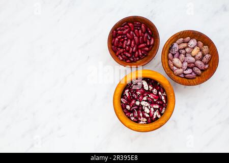 Set aus verschiedenen getrockneten Nierenleguminosen in Holzschüsseln Stockfoto