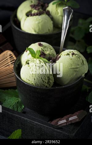 Matcha-Minze-Eis mit Schokoladenstückchen in einer schwarzen Schüssel Stockfoto