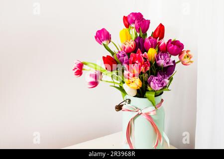Strauß bunter Tulpen in weißer Dose Stockfoto