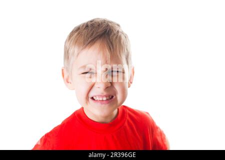 Ein kleiner Junge im roten T-Shirt, eine emotionale Reaktion. Stockfoto