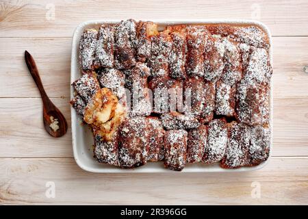 Brot mit Zimtzucker in einer Porzellanschale auseinanderziehen (Draufsicht) Stockfoto