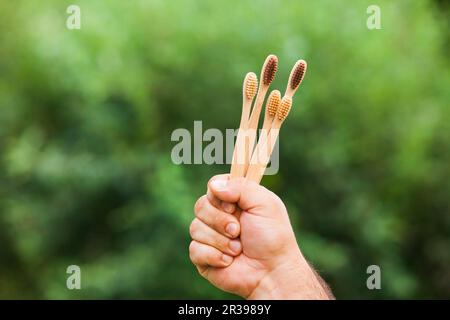 Hand mit Bambus Zahnbürsten auf die Natur im Freien Stockfoto