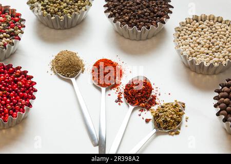 Bunte Gewürze in Löffeln, Pfefferflocken Stockfoto