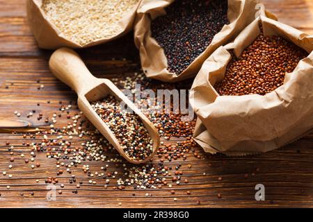 Samen von weißen, roten und schwarzen Quinoa auf dem Tisch Stockfoto